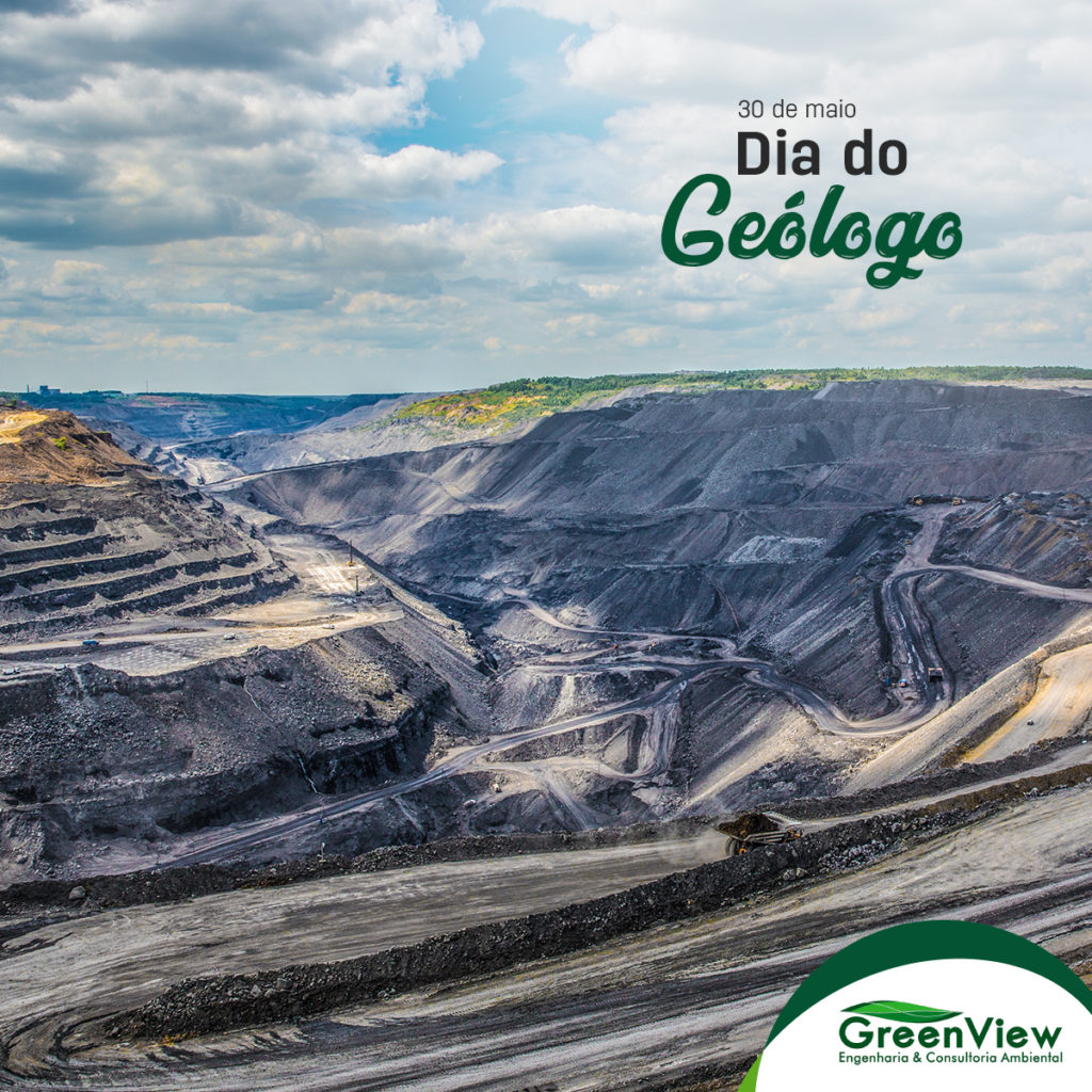 Imagem de uma cava de mineração, com um caminhão levando minério e acima da imagem o texto 30 de maio dia do geólogo